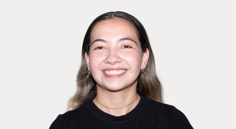 Happy young woman with long hair smiling, portrait for Stable Card News.