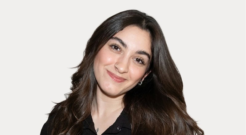 Young woman with long dark hair smiling, professional headshot for Stable Card News.