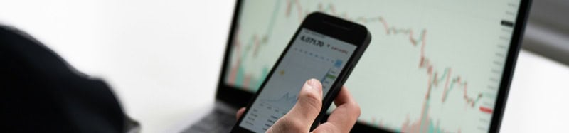 Person analyzing stock charts on smartphone for trading insights.